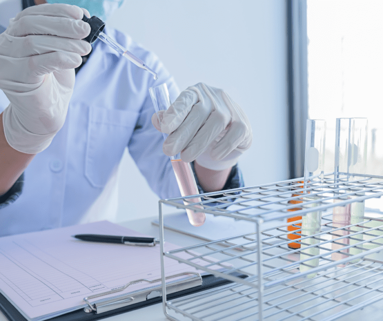 Penetrant testing with a lab technician using beakers to conduct tests.